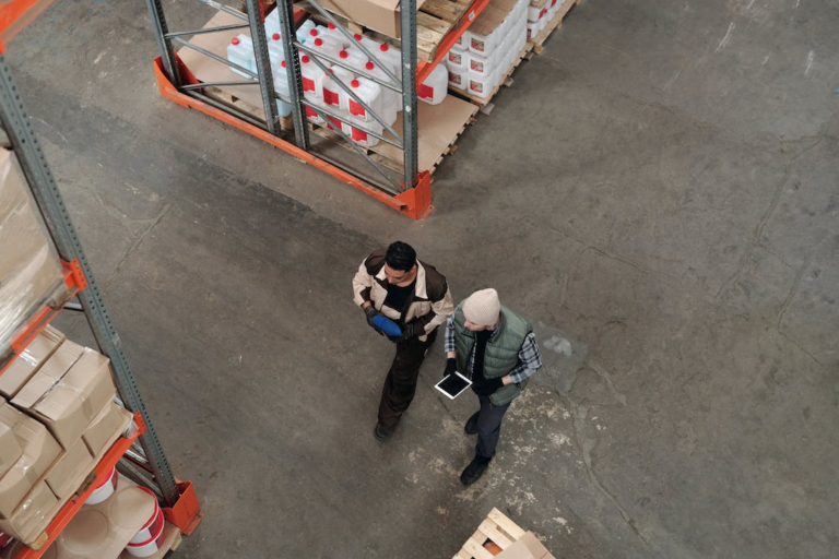 an aerial view of two men working in a warehouse.