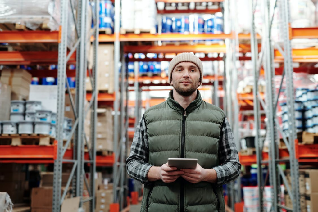 person standing with an iPad in a warehouse.